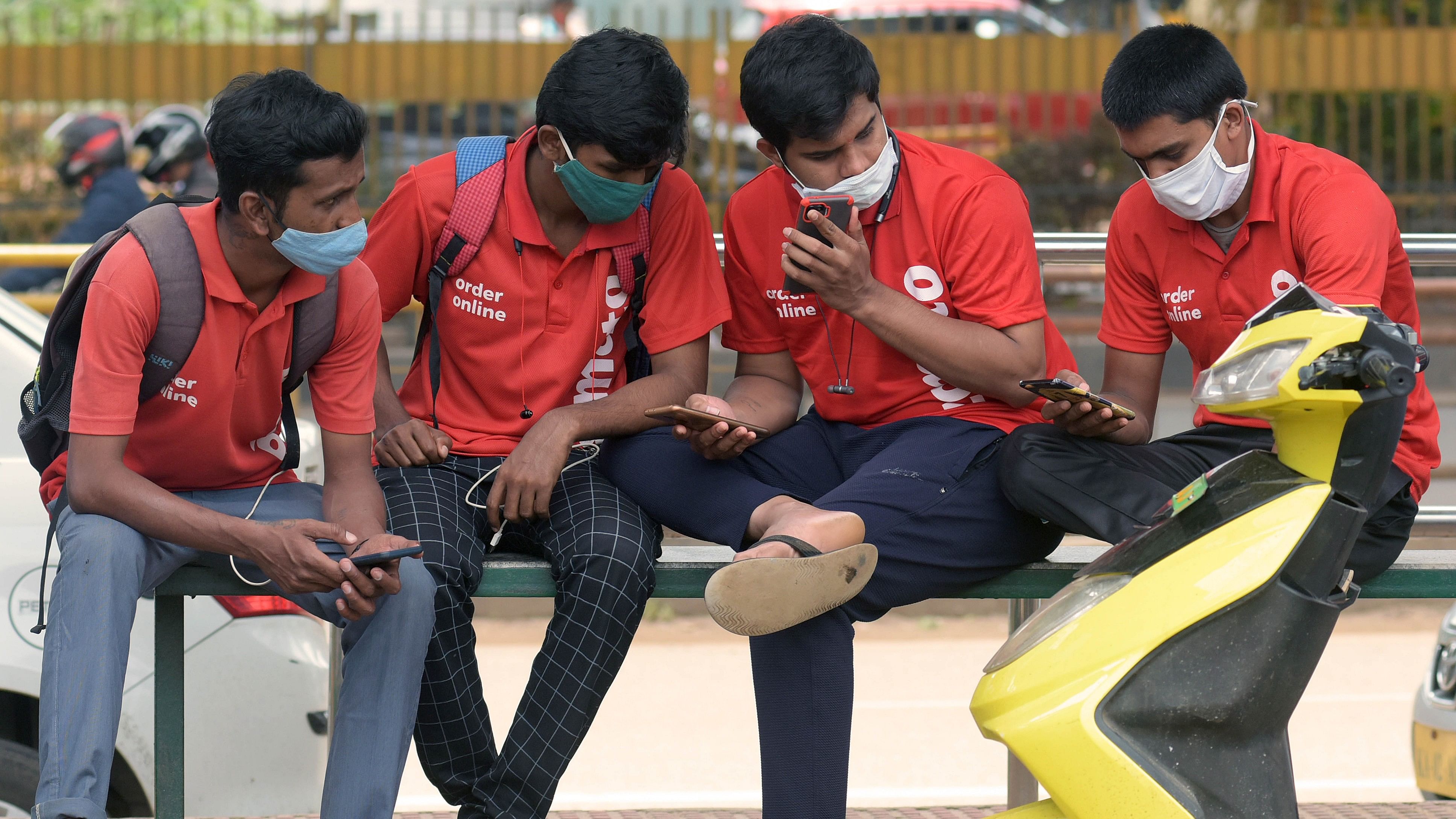 <div class="paragraphs"><p>Delivery executives wait outside a restaurant to pick-up orders</p></div>